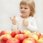 A child counting apples.